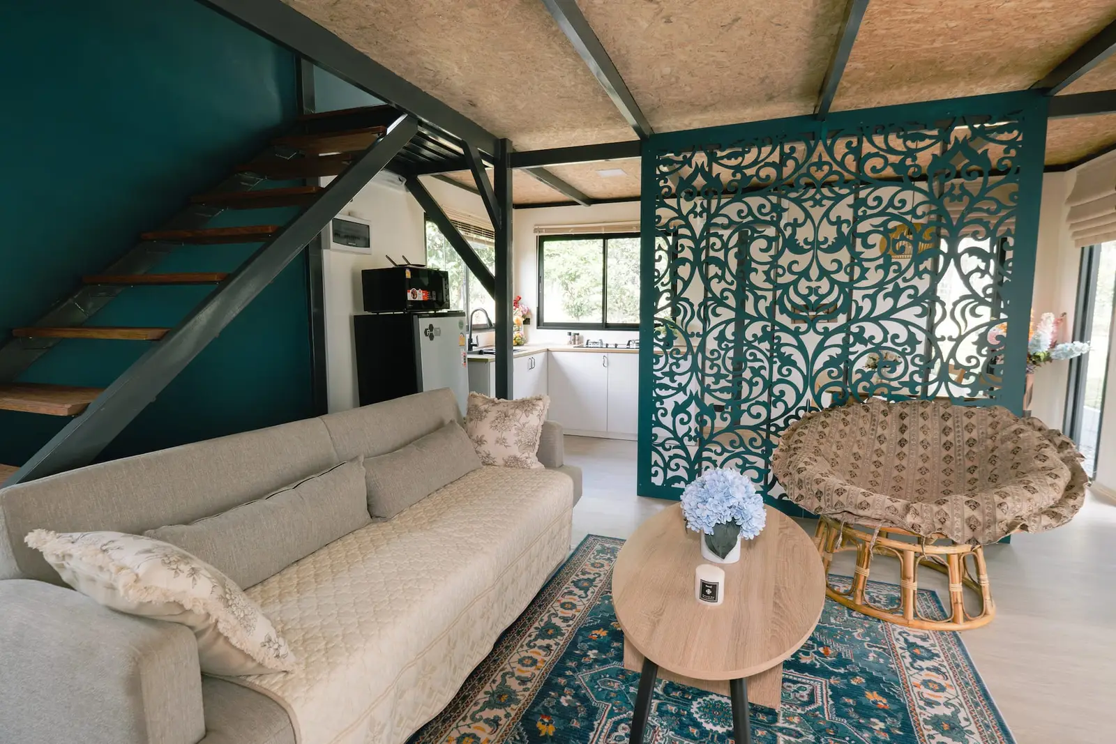 Living room with sofa, rattan chair and carved screen