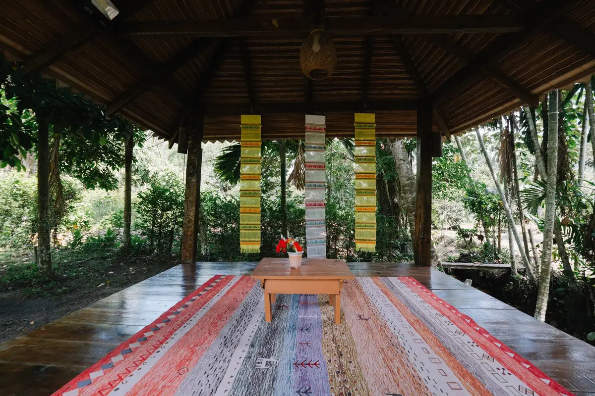Open-air wooden sala with woven rugs